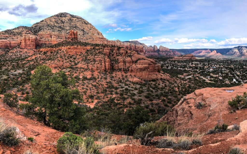 Sedona's signature red rock formations with juniper forests and blue skies.